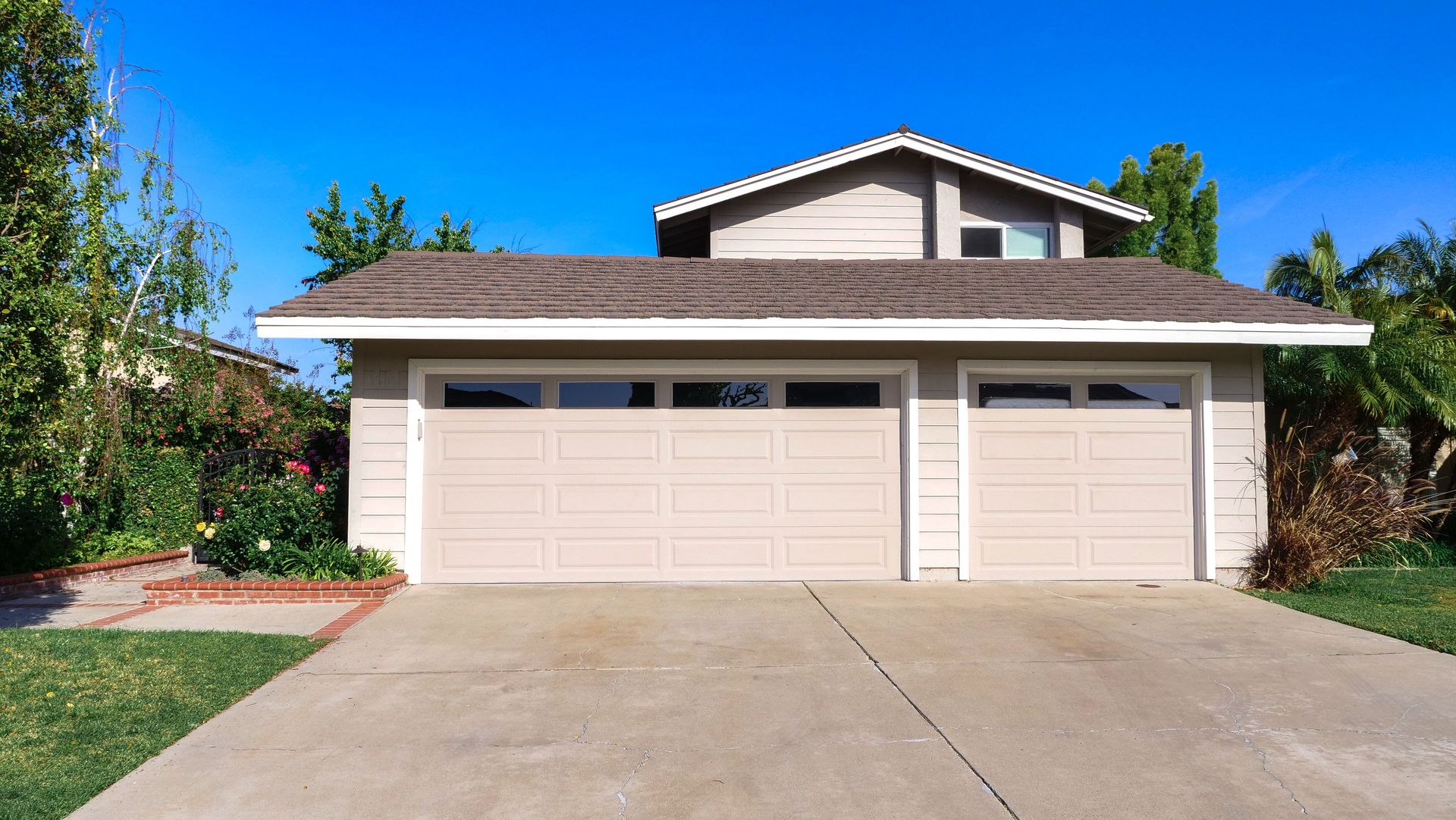 Exterior view of a cozy suburban house with a double garage, perfect for families.